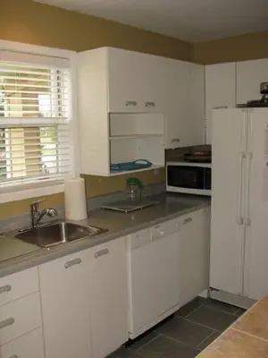 a kitchen with white cabinets and a sink and a refrigerator at Arkadia Condo Magog in Magog-Orford