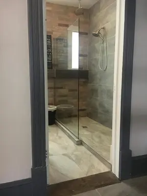 a shower with a glass door in a bathroom at Suites North Hatley in North Hatley