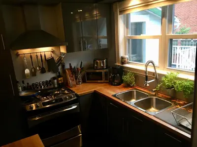 a kitchen with a stove and a sink and a window at Suites North Hatley in North Hatley