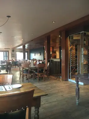 a restaurant with wooden tables and chairs and a dining room at Suites North Hatley in North Hatley