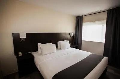 a bedroom with a large white bed with a window at Hotel Newstar Montréal in Montréal