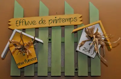 a green and white fence with signs on it at Hotellerie Jardins de Ville in Sherbrooke