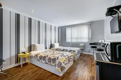 a bedroom with two beds and a microwave at Auberge St. Jacques in Montréal
