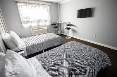 a room with two beds and a flat screen tv at Auberge St. Jacques in Montréal