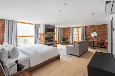 a bedroom with a large bed and a living room at Lofts du Vieux-Port by Gray Collection in Montréal