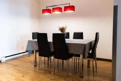 a dining room with a table and black chairs at Lofts du Vieux-Port by Gray Collection in Montréal