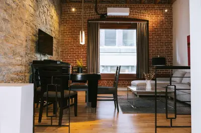 a room with a table and chairs and a brick wall at Lofts du Vieux-Port by Gray Collection in Montréal