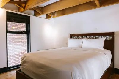 a bedroom with a large white bed and a window at Lofts du Vieux-Port by Gray Collection in Montréal