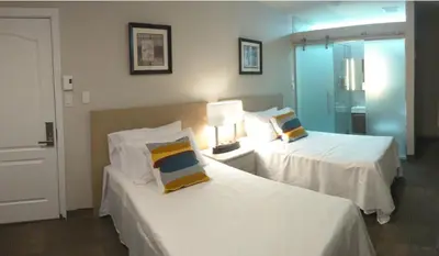 a hotel room with two beds and a lamp at Hotel Le Deville in Montréal