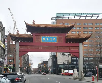 a gate with a chinese sign in the middle of a street at Hotel Le Deville in Montréal