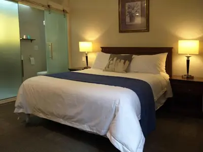 a bedroom with a large bed with two lamps at Hotel Le Deville in Montréal