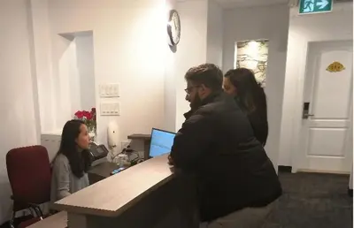 a group of people standing around a desk with a computer at Hotel Le Deville in Montréal