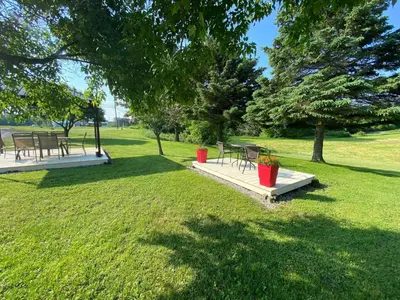 a park with tables and chairs in the grass at Motel Exquise in Coaticook