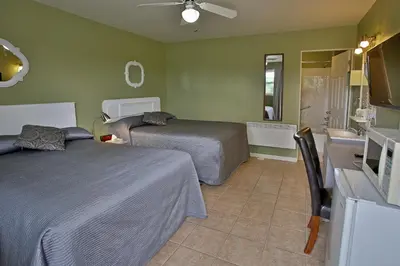 a hotel room with two beds and a bathroom at Motel Exquise in Coaticook