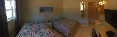 a bedroom with two beds and a tv at Motel Exquise in Coaticook