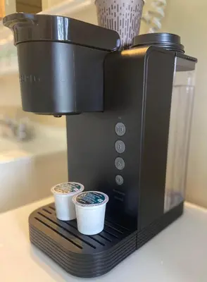 a coffee maker with two cups on a counter at Motel Exquise in Coaticook