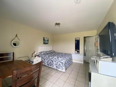 a bedroom with a bed and a desk and a television at Motel Exquise in Coaticook