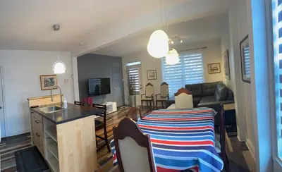 a kitchen and living room with a table and a sink at Le 2316 in Saint-Hyacinthe