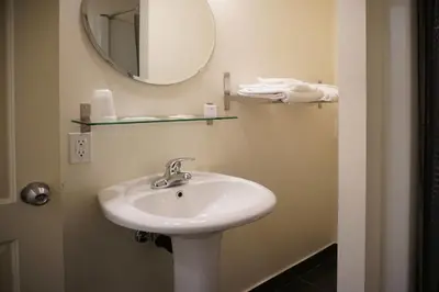 a bathroom with a sink and a mirror at Hotel Le Mirage in Saint-Basile-le-Grand