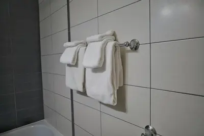 a bathroom with white towels hanging on a wall at Hotel Le Mirage in Saint-Basile-le-Grand