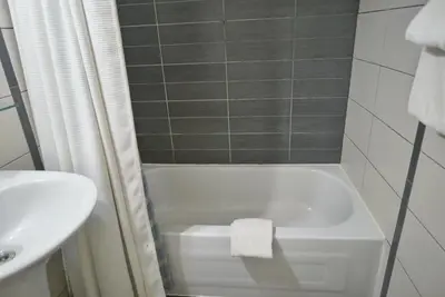 a bathroom with a white tub and a sink at Hotel Le Mirage in Saint-Basile-le-Grand