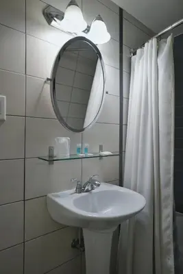 a bathroom with a sink and a mirror at Hotel Le Mirage in Saint-Basile-le-Grand