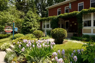 a garden in front of a house with flowers at Au Virage B&B in Magog-Orford