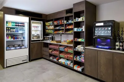 a store room with a refrigerator and shelves with food at Doubletree By Hilton Montreal Airport in Dorval