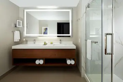 a bathroom with a sink and a mirror and a shower at Doubletree By Hilton Montreal Airport in Dorval