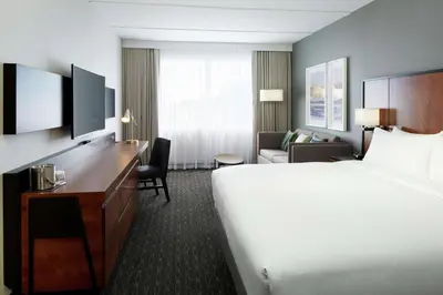 a hotel room with a bed and a desk at Doubletree By Hilton Montreal Airport in Dorval
