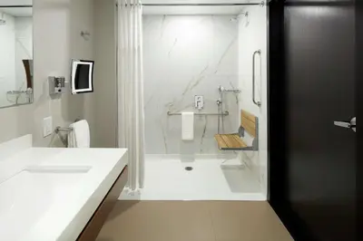 a white bathroom with a shower and a sink at Doubletree By Hilton Montreal Airport in Dorval