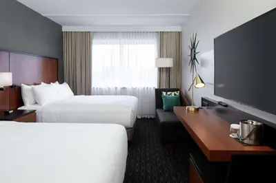 a hotel room with two beds and a desk at Doubletree By Hilton Montreal Airport in Dorval
