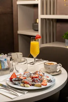 a plate of food on a table with a glass of orange juice at Doubletree By Hilton Montreal Airport in Dorval
