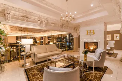 a lobby with a couch and chairs and a fireplace at Hôtel Birks Montréal in Montréal