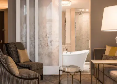 a living room with a bath tub and two chairs at Hôtel Birks Montréal in Montréal