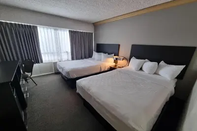 a hotel room with two beds and a window at Travelodge by Wyndham Trois-Rivieres in Trois-Rivières