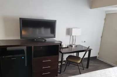 a hotel room with a desk with a television and a deskablish at Travelodge by Wyndham Trois-Rivieres in Trois-Rivières
