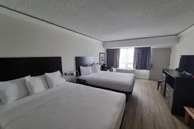 a hotel room with two beds and a television at Travelodge by Wyndham Trois-Rivieres in Trois-Rivières