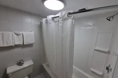 a bathroom with a shower curtain and a toilet at Travelodge by Wyndham Trois-Rivieres in Trois-Rivières