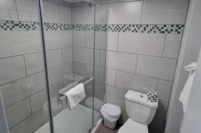 a bathroom with a toilet and a glass shower at Travelodge by Wyndham Trois-Rivieres in Trois-Rivières