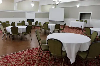 a conference room with tables and chairs and a whiteboard at Travelodge by Wyndham Trois-Rivieres in Trois-Rivières