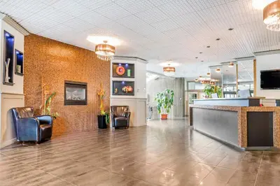 a lobby with chairs and a bar in a building at Travelodge by Wyndham Trois-Rivieres in Trois-Rivières