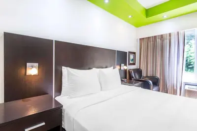 a hotel room with a large bed and a chair at Travelodge by Wyndham Trois-Rivieres in Trois-Rivières