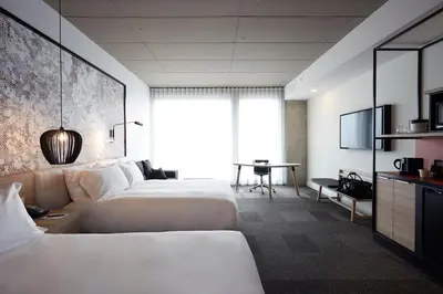 a hotel room with two beds and a desk at Hôtel Escad Quartier DIX30 in Brossard