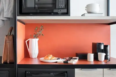 a table with a plate of food and a microwave at Hôtel Escad Quartier DIX30 in Brossard
