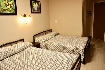 two twin beds in a room with at Hotel Victor in Montréal