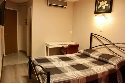 a hotel room with a bed and a desk at Hotel Victor in Montréal