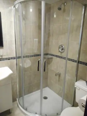 a shower with a glass door in a bathroom at Hotel Victor in Montréal