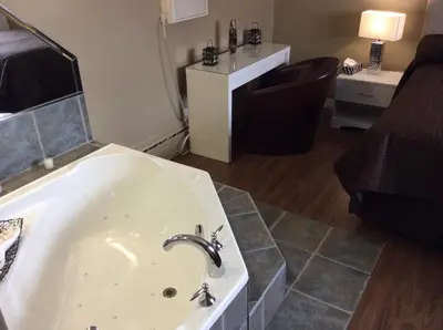 a bathroom with a bath tub with a sink at Miami Motel inc in Trois-Rivières