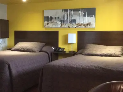 two beds in a room with yellow walls at Miami Motel inc in Trois-Rivières